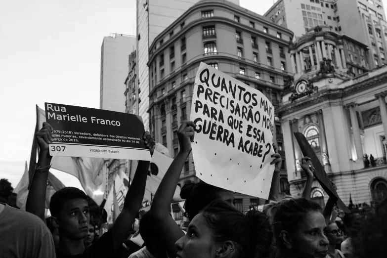 protestors hold placares in front of buildings