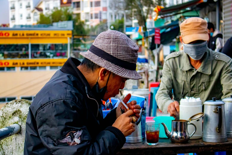 there are three men sitting at a table eating