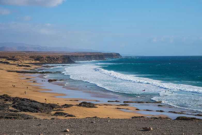 there is a wave crashing towards a sandy beach