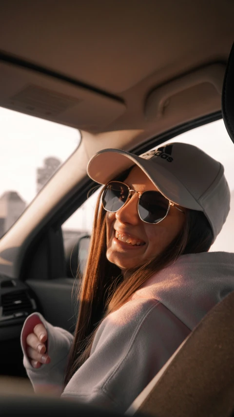 a woman in her car with the driver's hand out the window