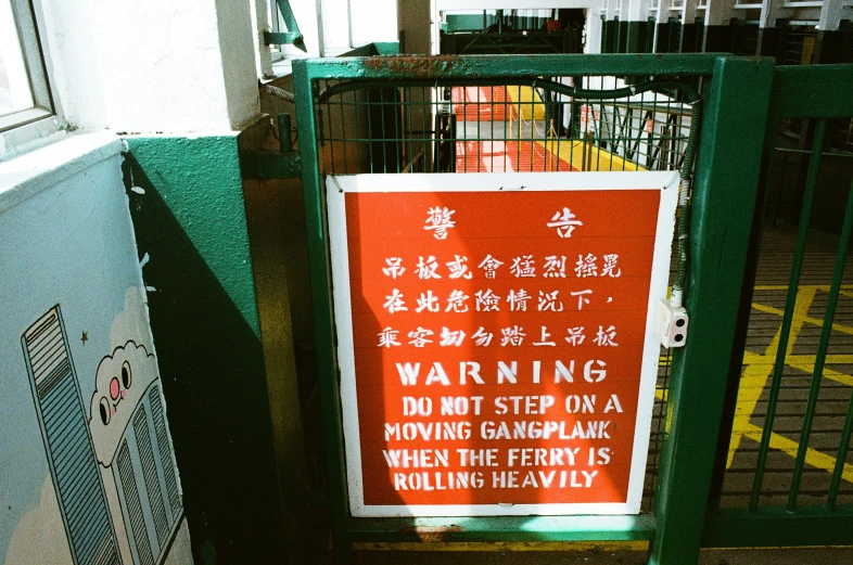 a warning sign attached to a gate near a building