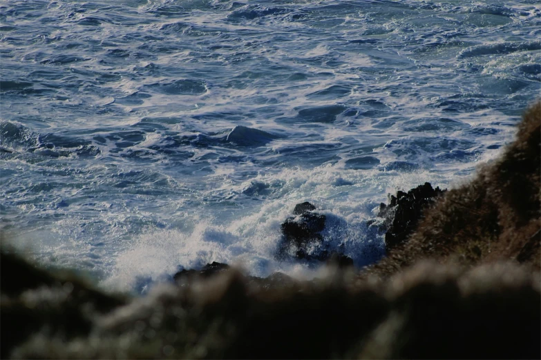 view from rocks with crashing waves near shore
