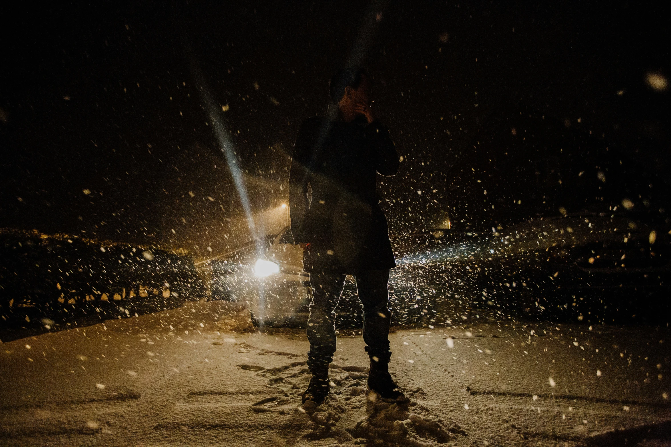 the person is walking in the snow with his umbrella