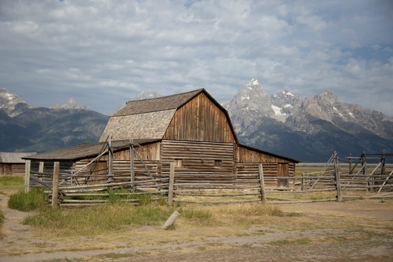 an old barn with no roof stands in a desert pasture