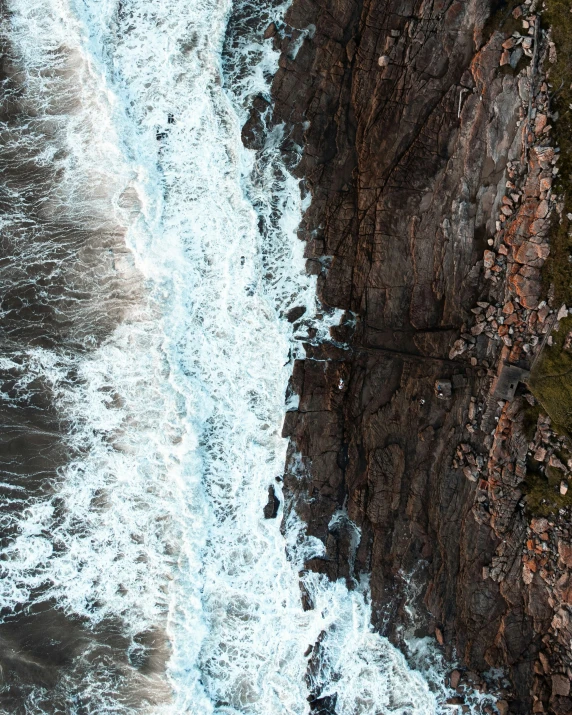 an aerial view of a cliff and a body of water