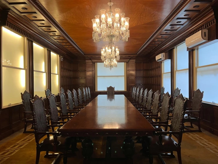 a room with a large dining table and chandelier