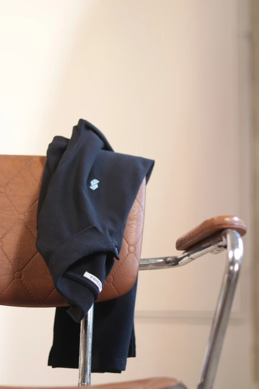 a brown folding chair and a blue napkin on the armrest