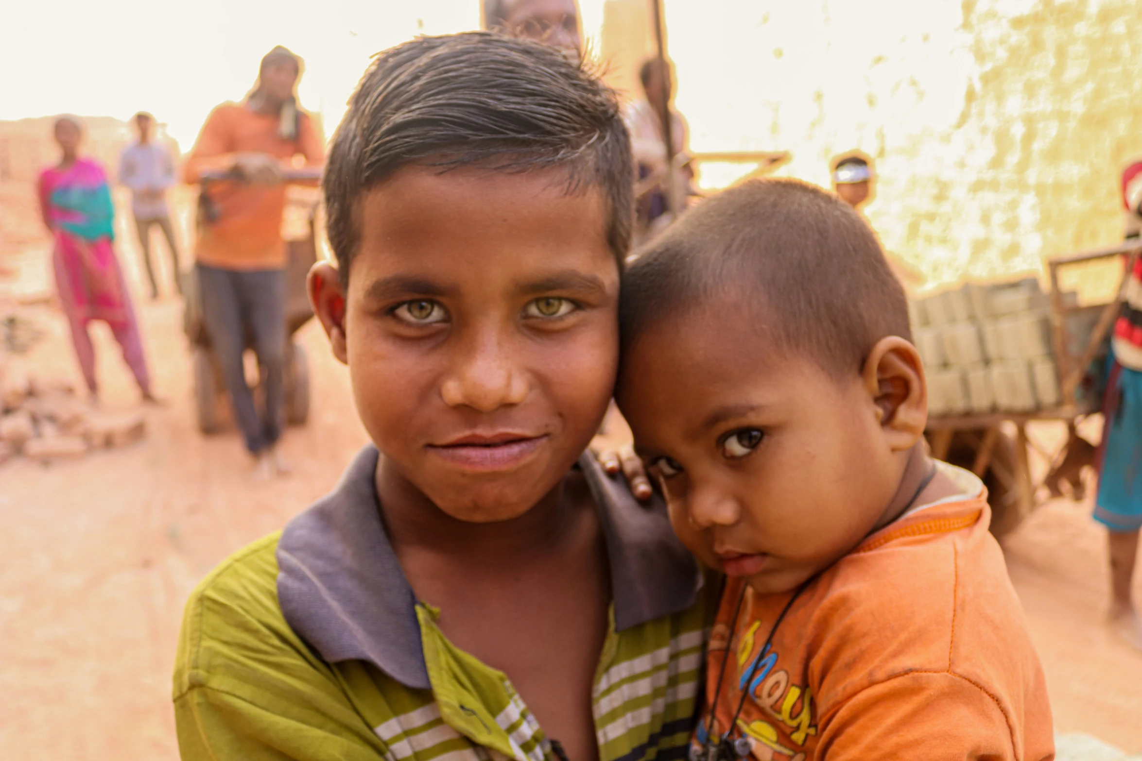 a boy and girl, both with eyes open, hugging