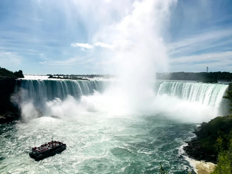 a boat is going under a very large waterfall