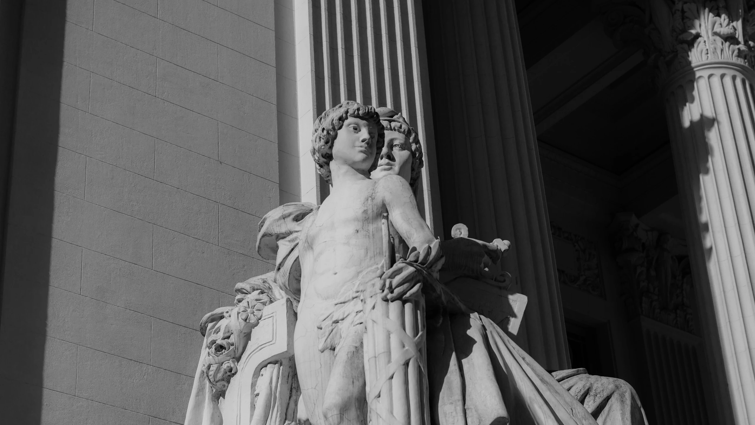 a statue stands next to an ancient looking building