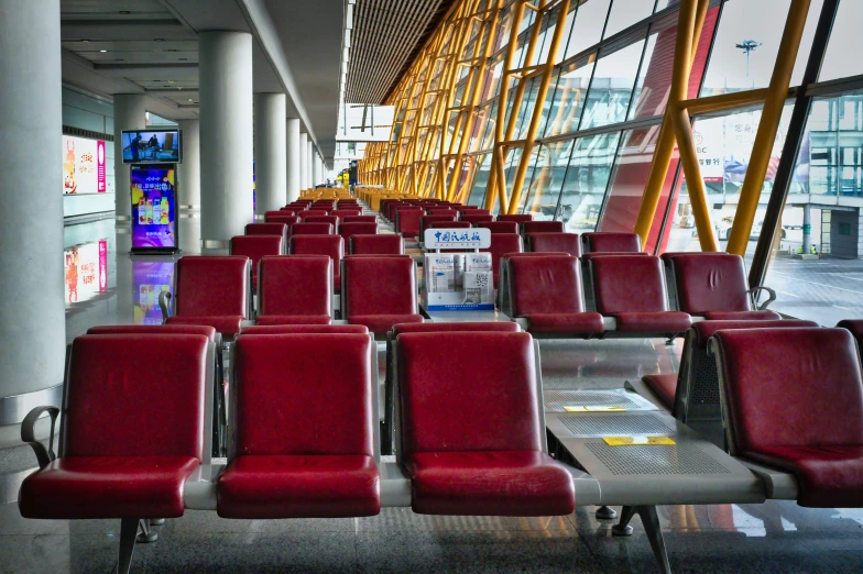 empty red chairs line up against a wall