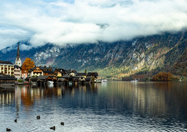 water reflecting a row of houses and a large mountain range