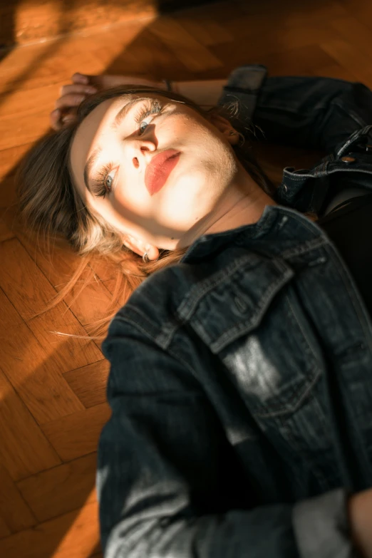 the young woman is sitting on the wooden floor