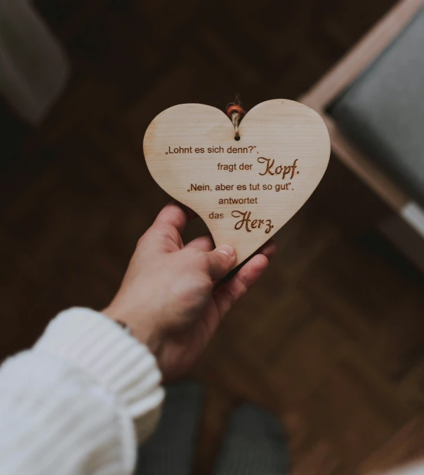 a heart shaped wooden decoration with a small wooden bird on it