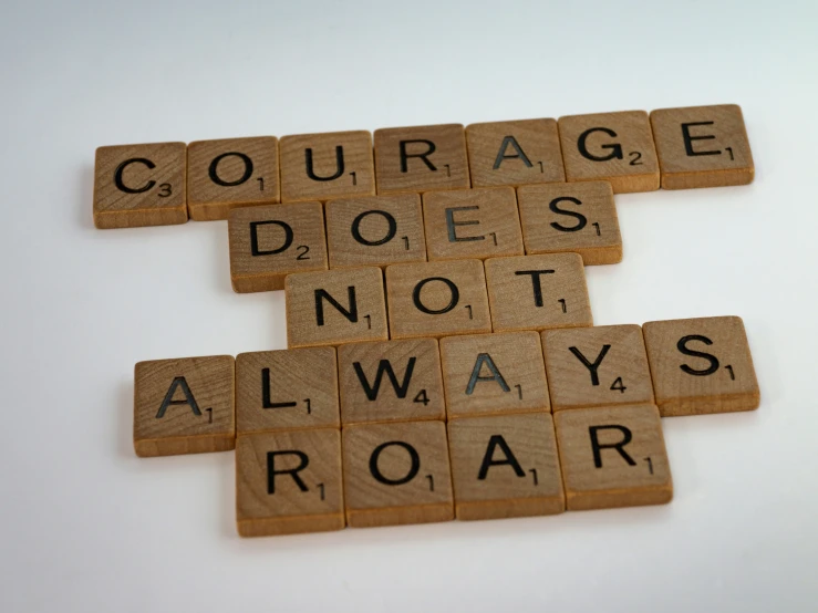 scrabbled letter tiles that spell out the words courage does not always roar