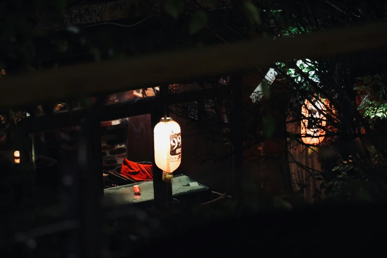 a lighted lantern and trees at night time