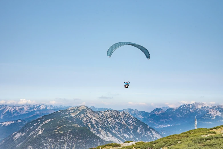 a person flying a kite high above mountains