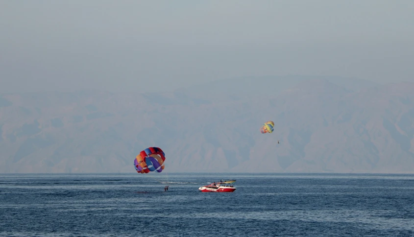 a couple of parasailers are in the middle of the water