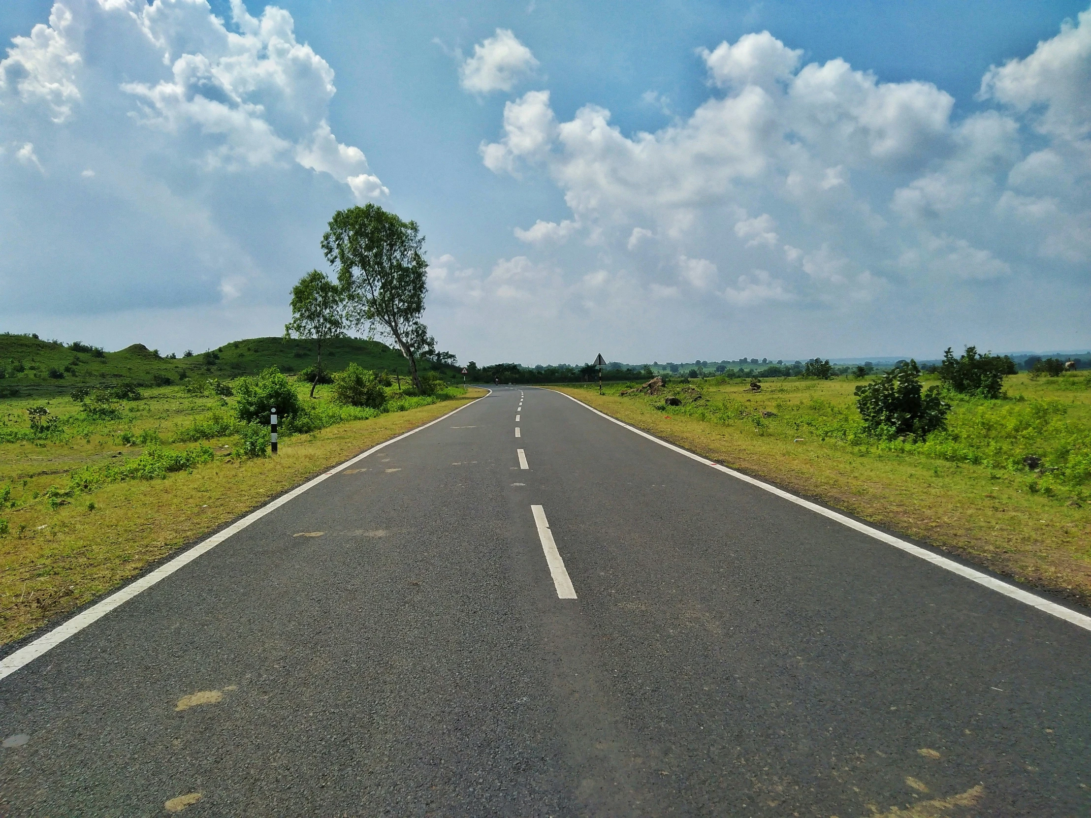 a rural highway near a field on a cloudy day