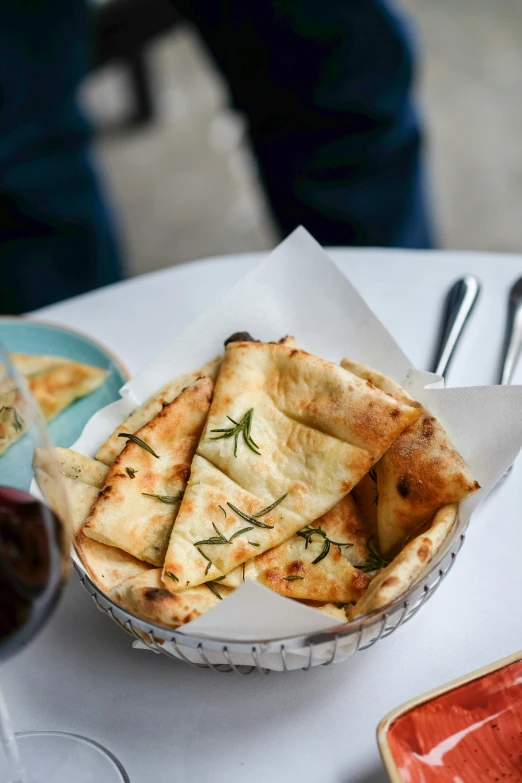 some small pita bread are in a basket on the table