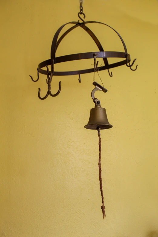 an old style metal bell is hung from a wall