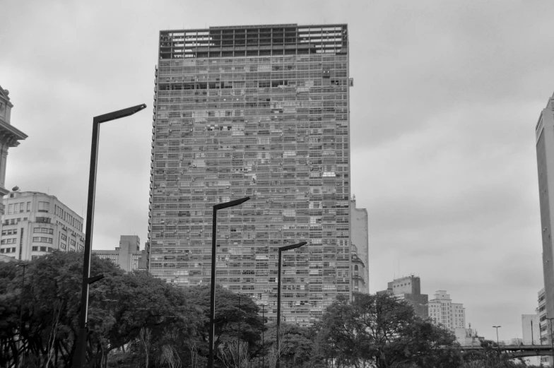 black and white pograph of a skyscr with a cloudy sky