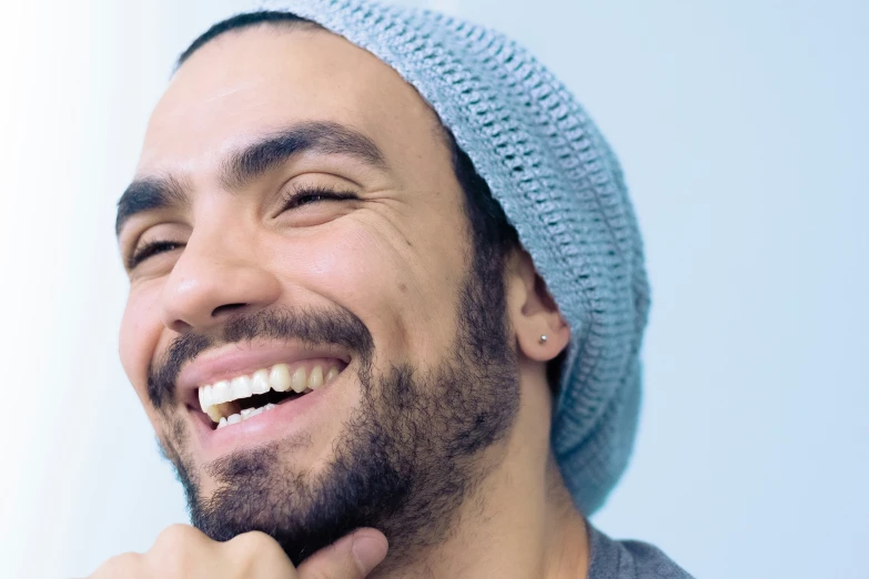 a man wearing a hat smiling at someone else