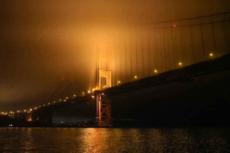 a long suspension bridge over the water at night