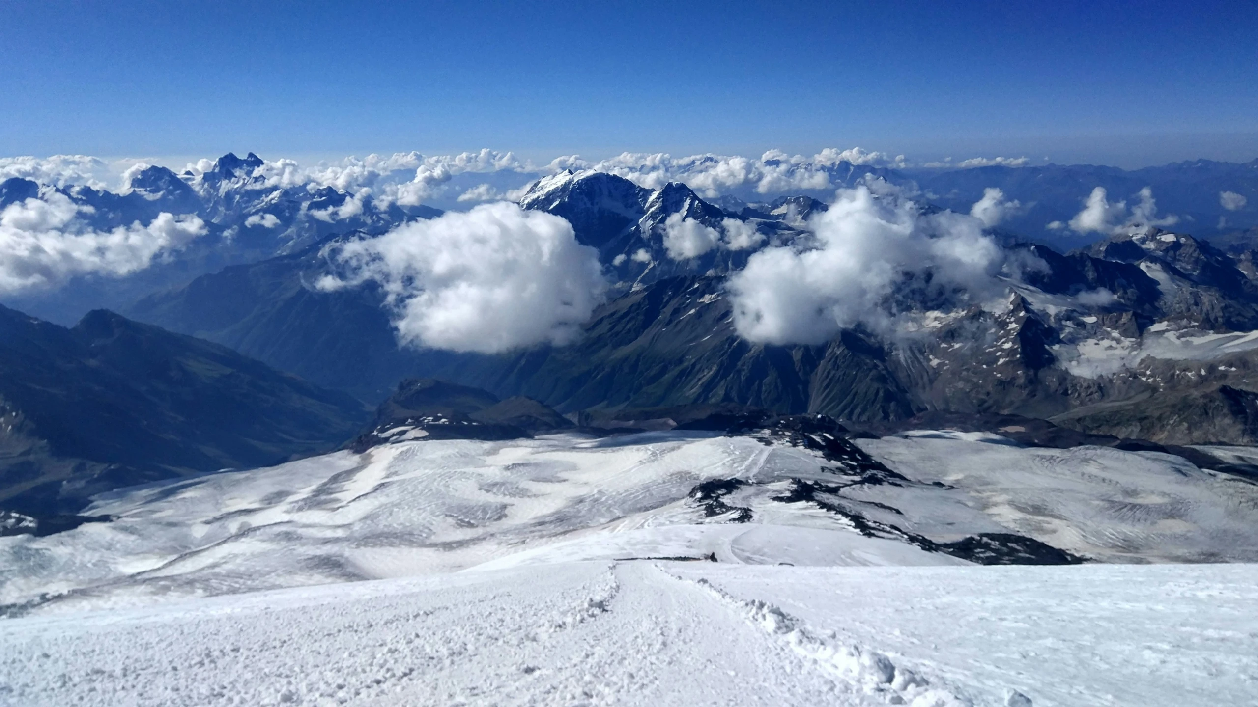 a scenic view looking down on a snow covered mountain