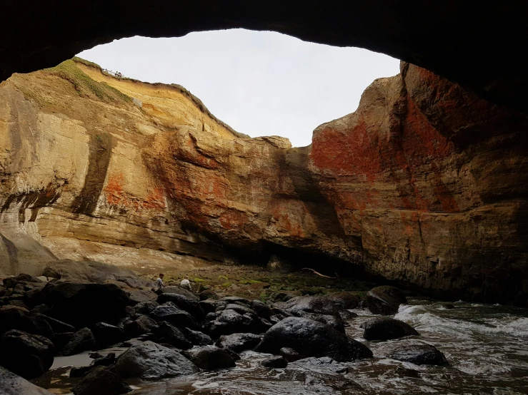 a cave is seen from the water of the lake