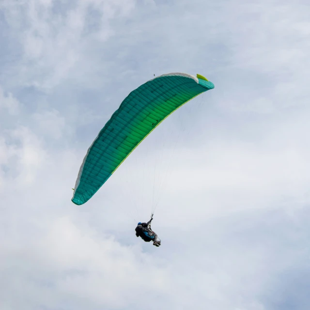 a person paragliding in the air in front of a white cloud