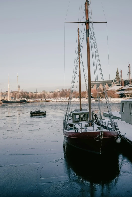 a boat sits docked in the water covered in ice