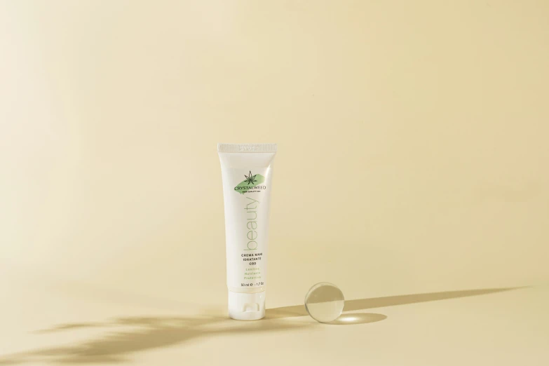 a white tube of hand cream sitting next to a white container