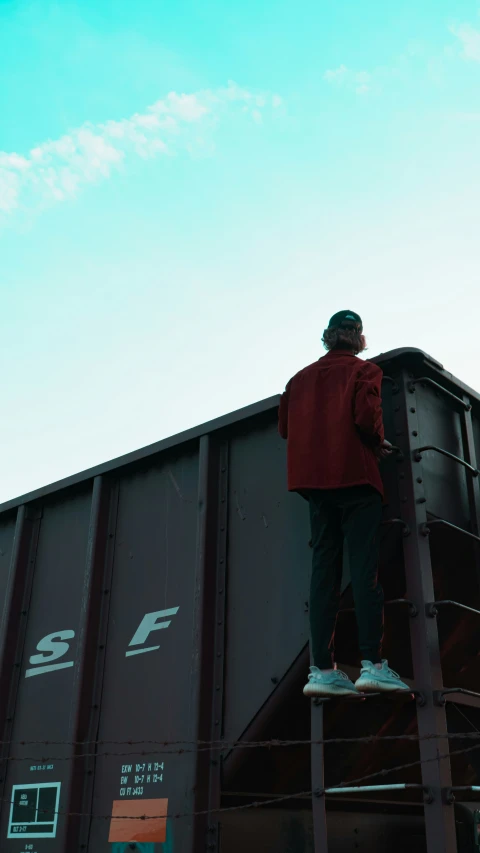 a man stands on a platform in front of train cars