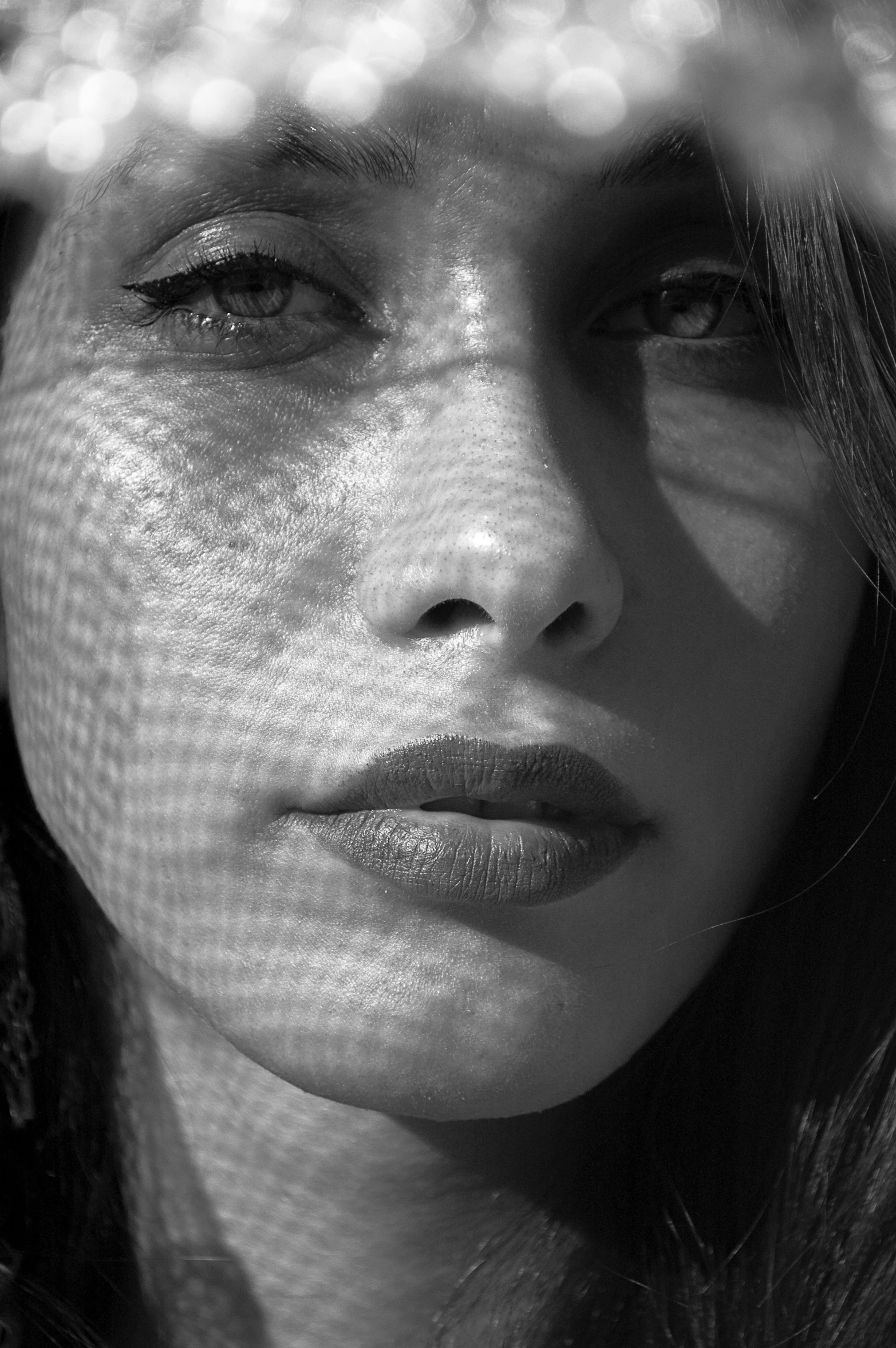 a woman looks through mesh as she holds her head