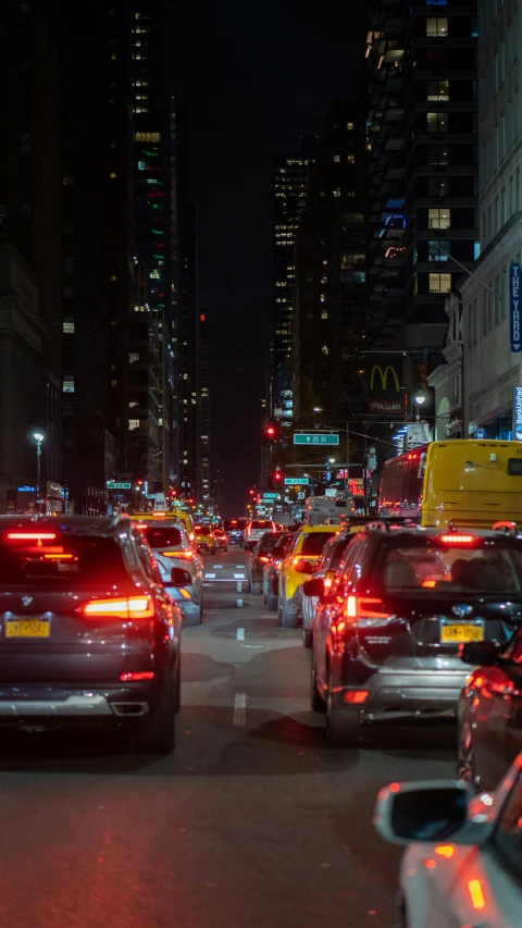 many cars are parked along the sidewalk in traffic