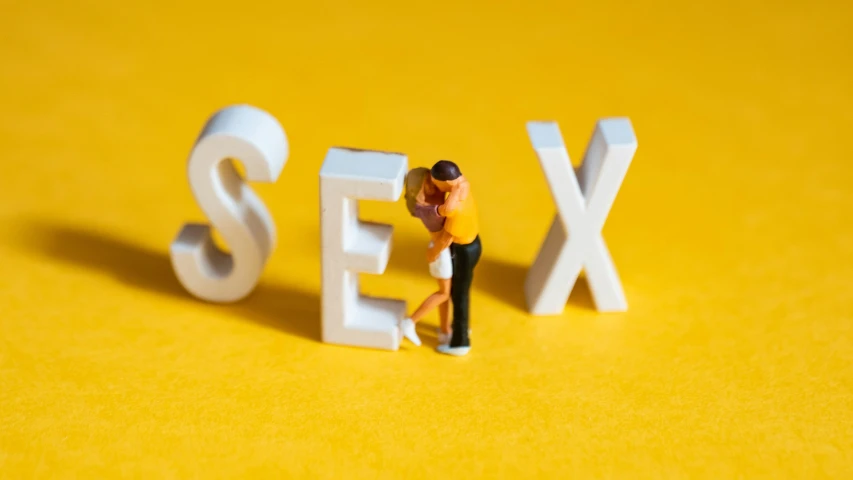 some kind of action figure with the letters sex in the background