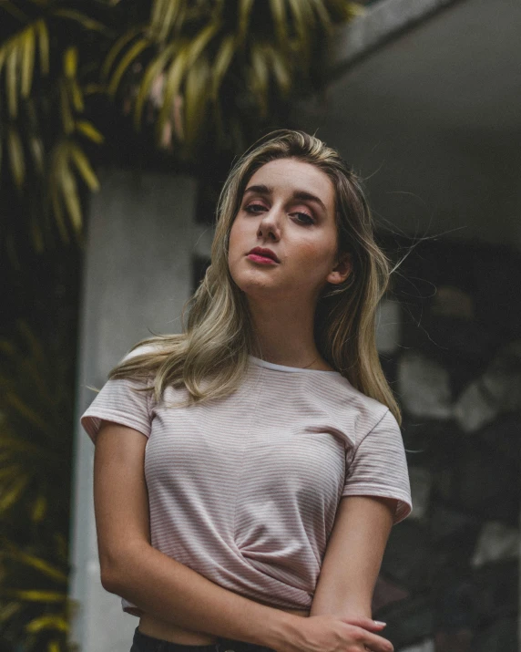 a woman standing with her arms crossed looking up