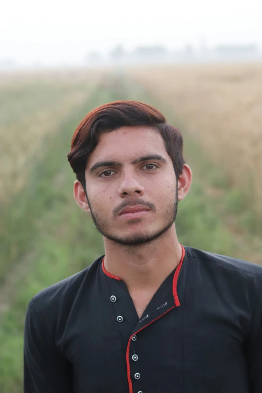 man standing in grassy field looking directly ahead