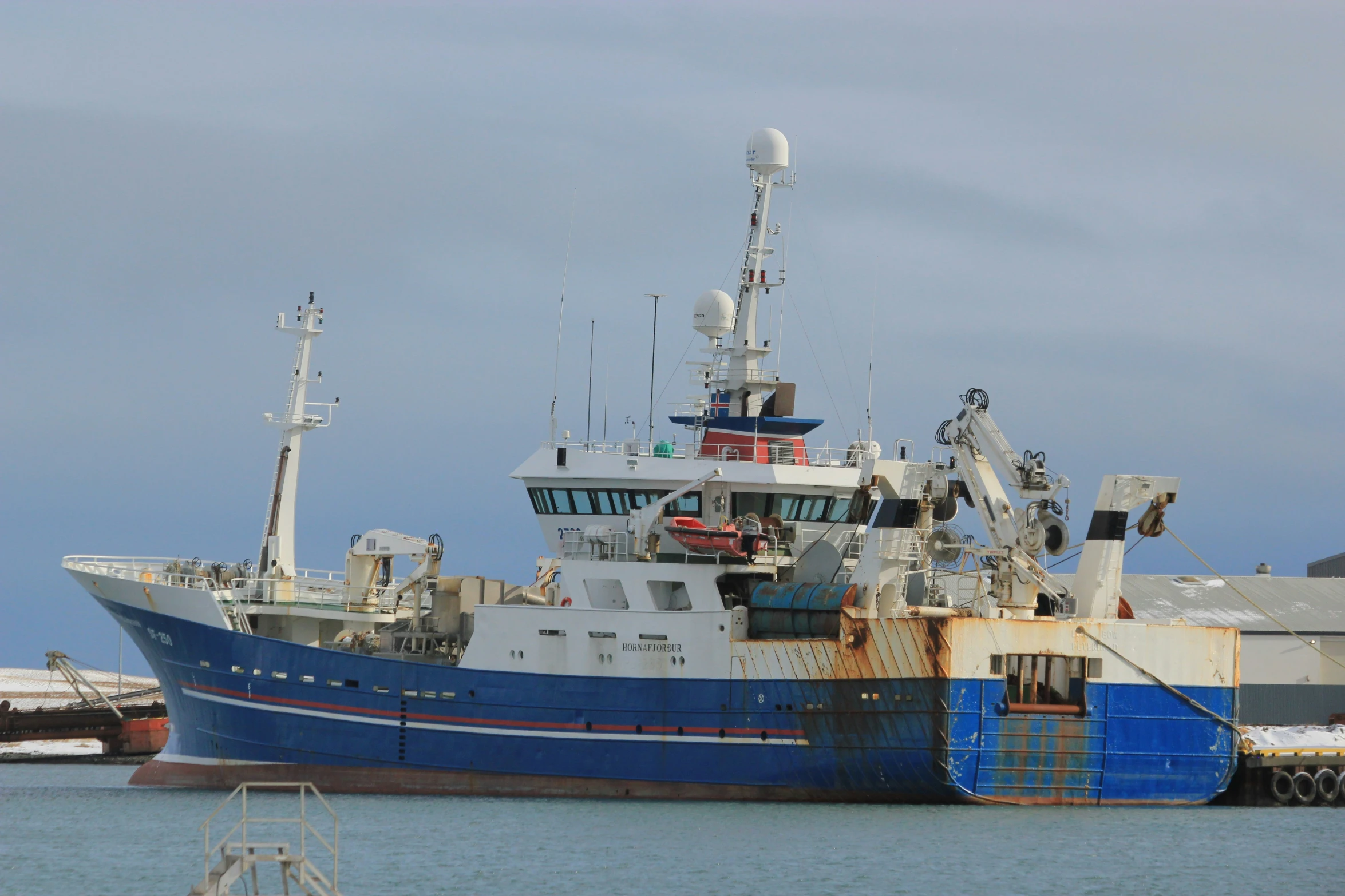 a boat sitting in the water near two other boats