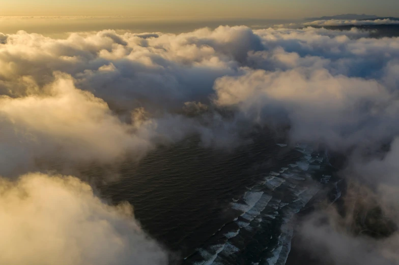 the clouds roll in over the shore where some houses sit