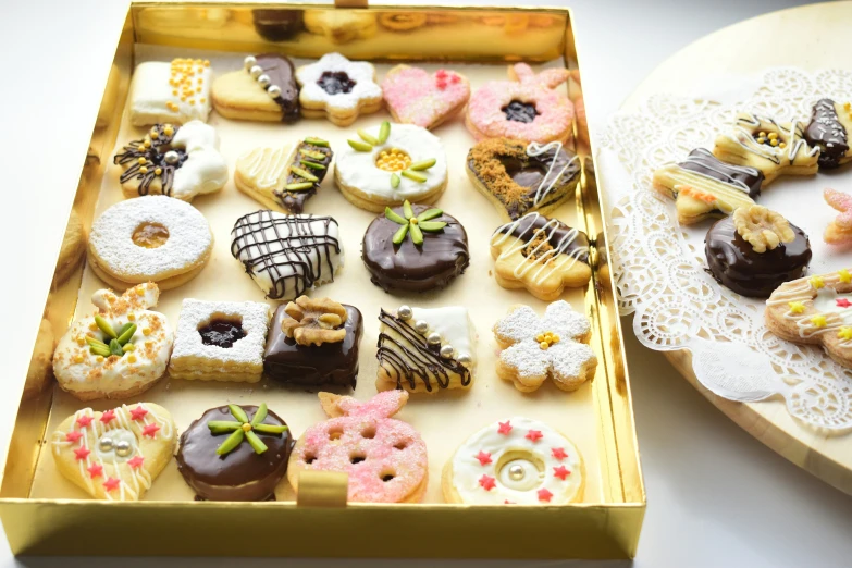 two boxes of decorated doughnuts sitting side by side