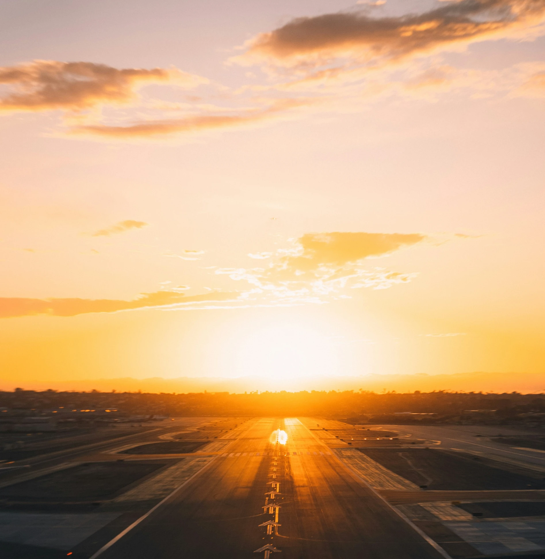 the sun sets in a desert with two planes parked in rows