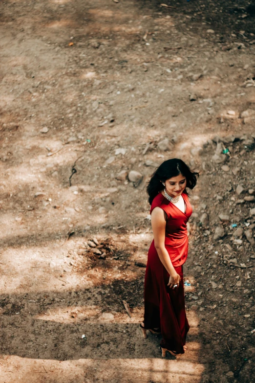 a girl in a red dress stands on the ground