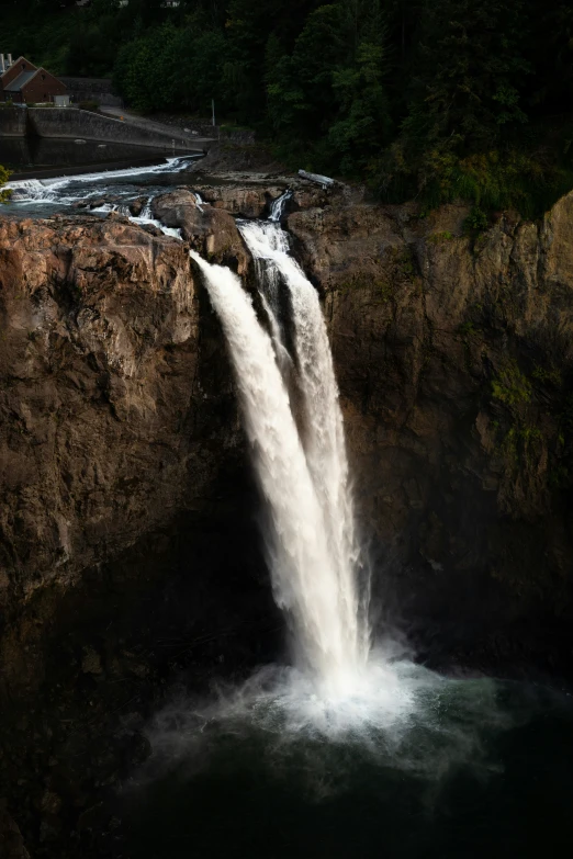 the water gusts from behind a rock wall