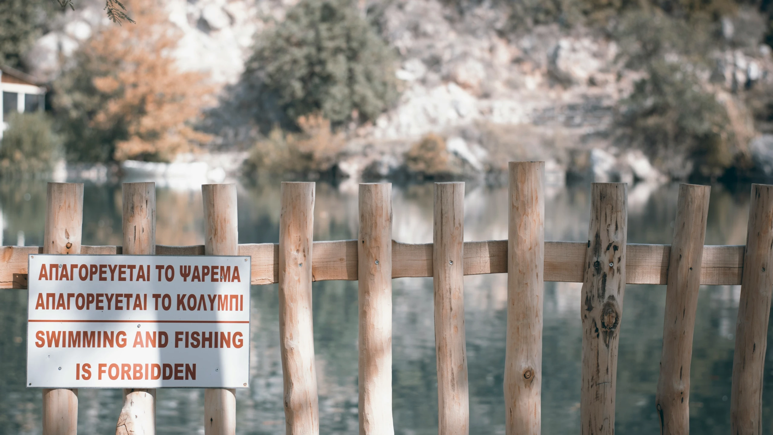 a wooden fence has a sign indicating the water level and where there is no swimming