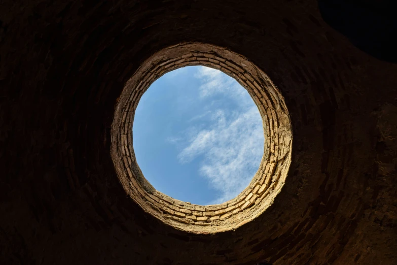 a round window with a sky in the background