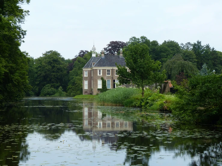 a beautiful house with many windows and doors overlooking the water