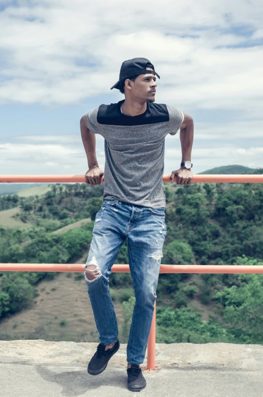 a man wearing a cap while standing on a railing