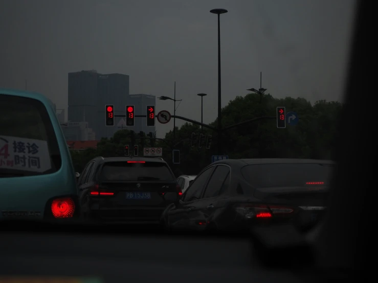 several cars stopped at an intersection in the evening